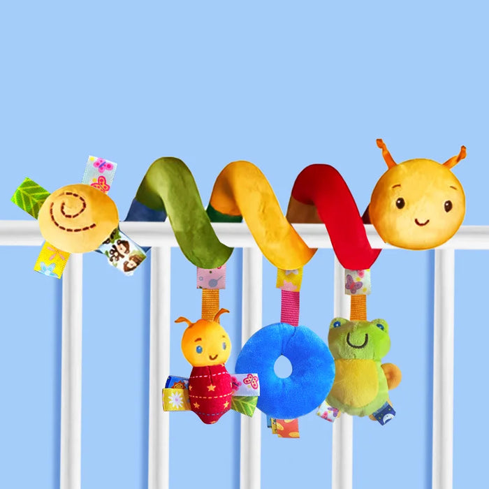 Colorful baby toy with various hanging elements on a crib rail against a blue background